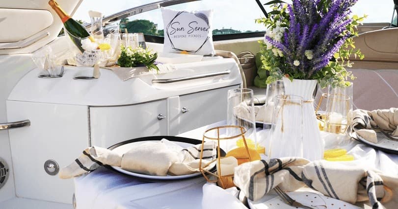 Luxury yacht dining setup on deck with coastal view and tableware
