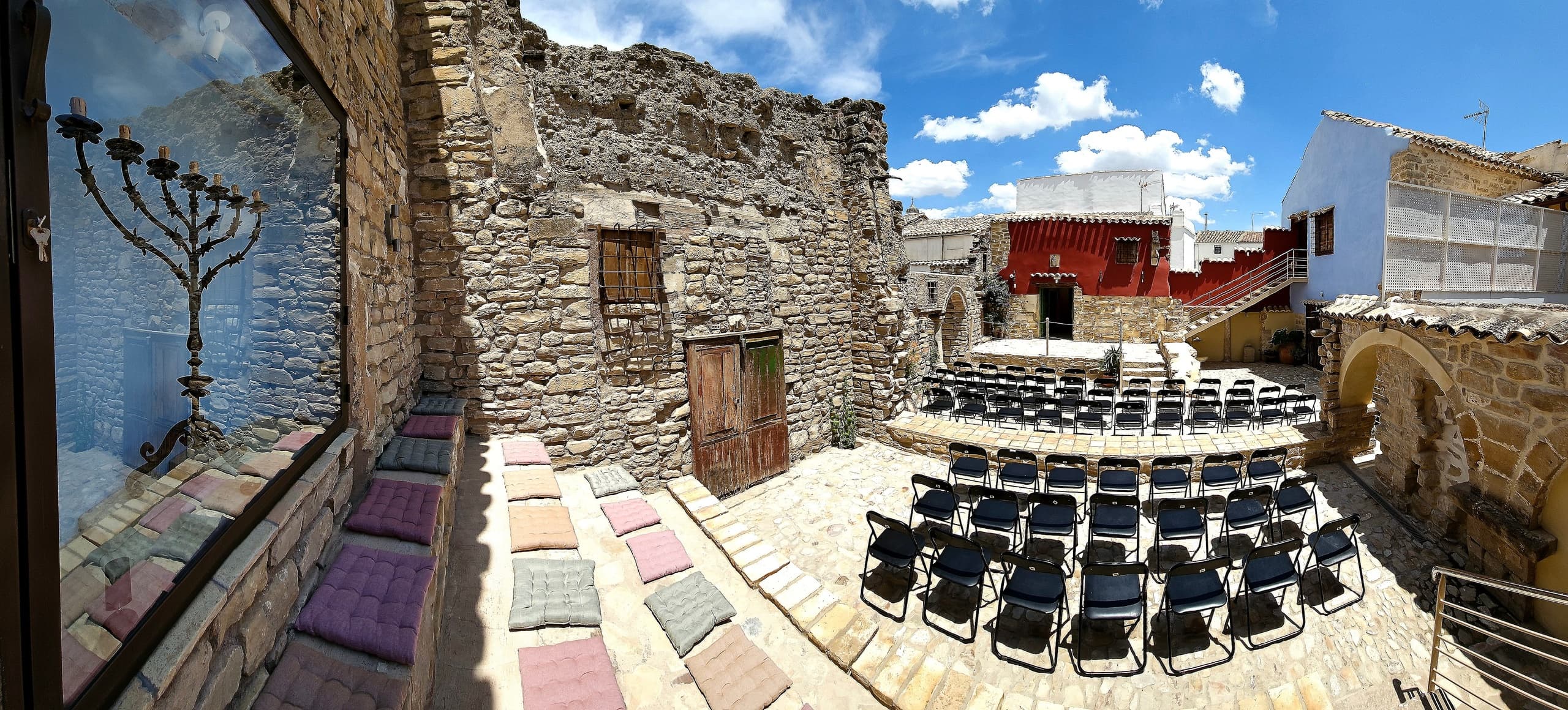 Panoramic courtyard ruins and outdoor seating at historic synagogue