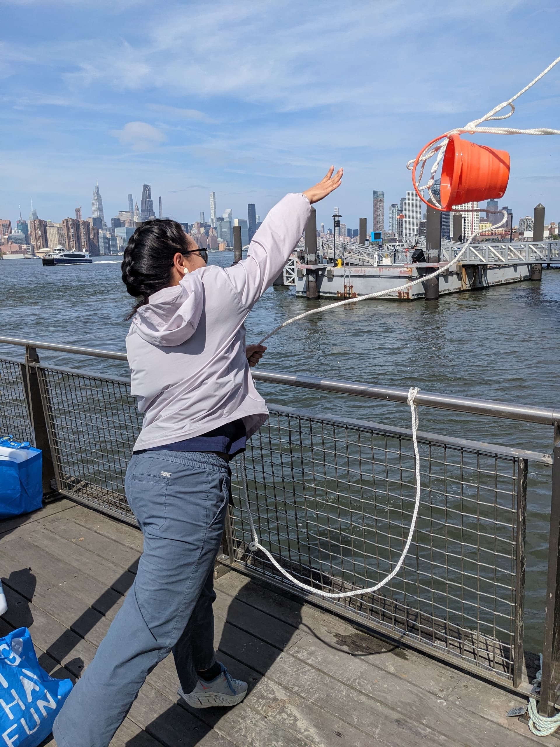 Field technician deploying water sampling gear from pier