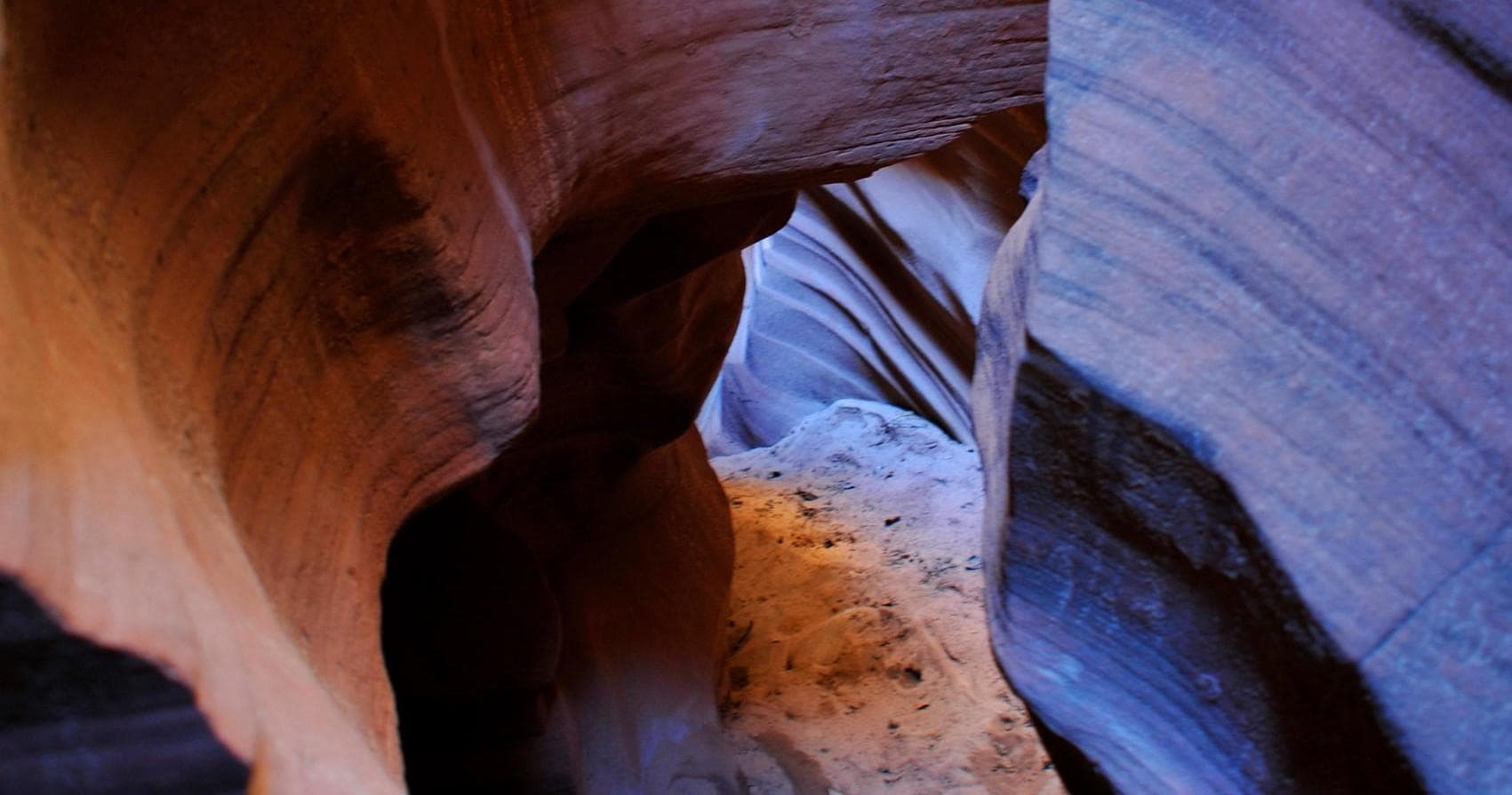 Close-up slot canyon passage with layered sandstone textures