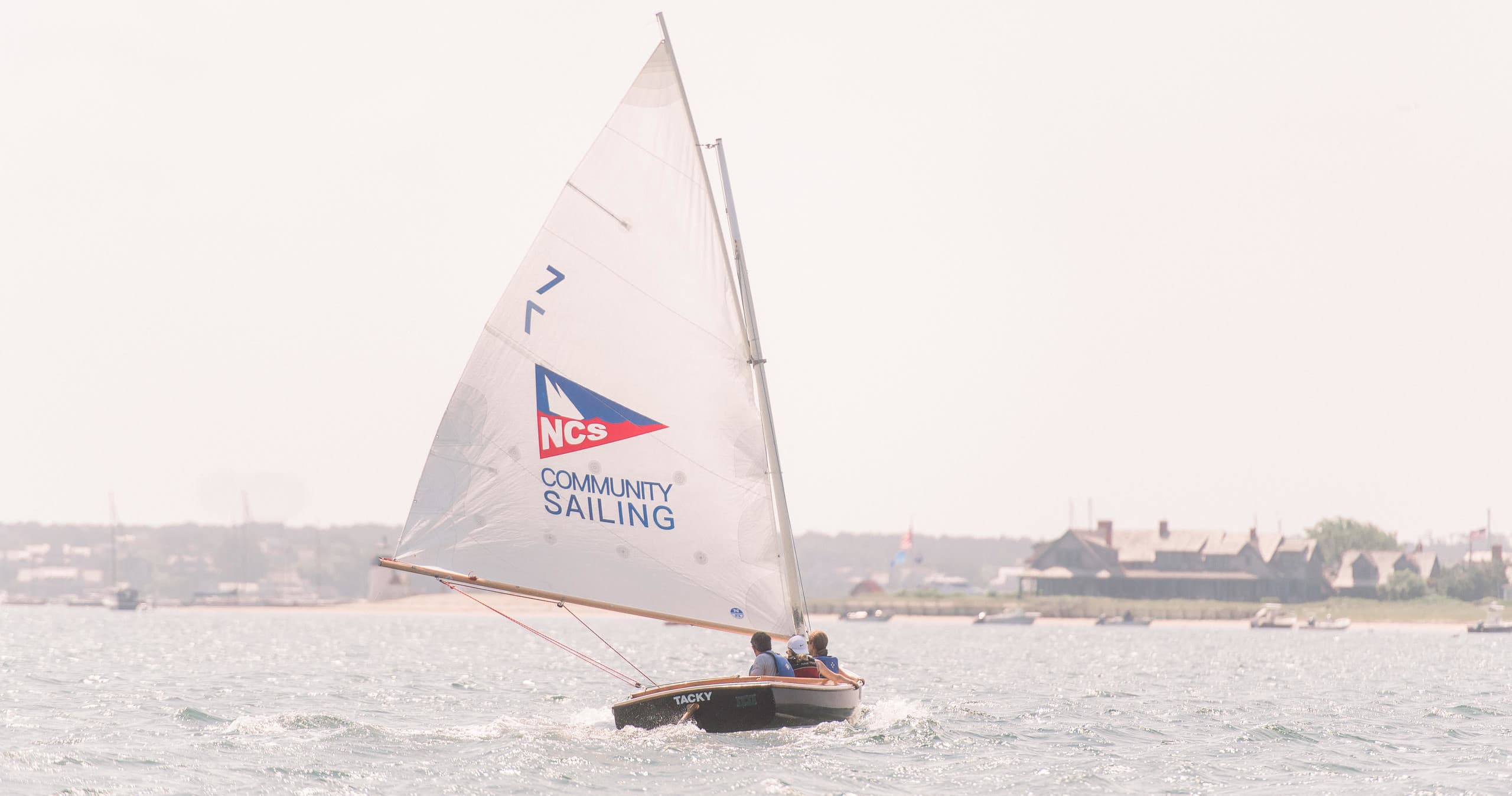Single sailboat cruising near Nantucket harbor, pastel sky