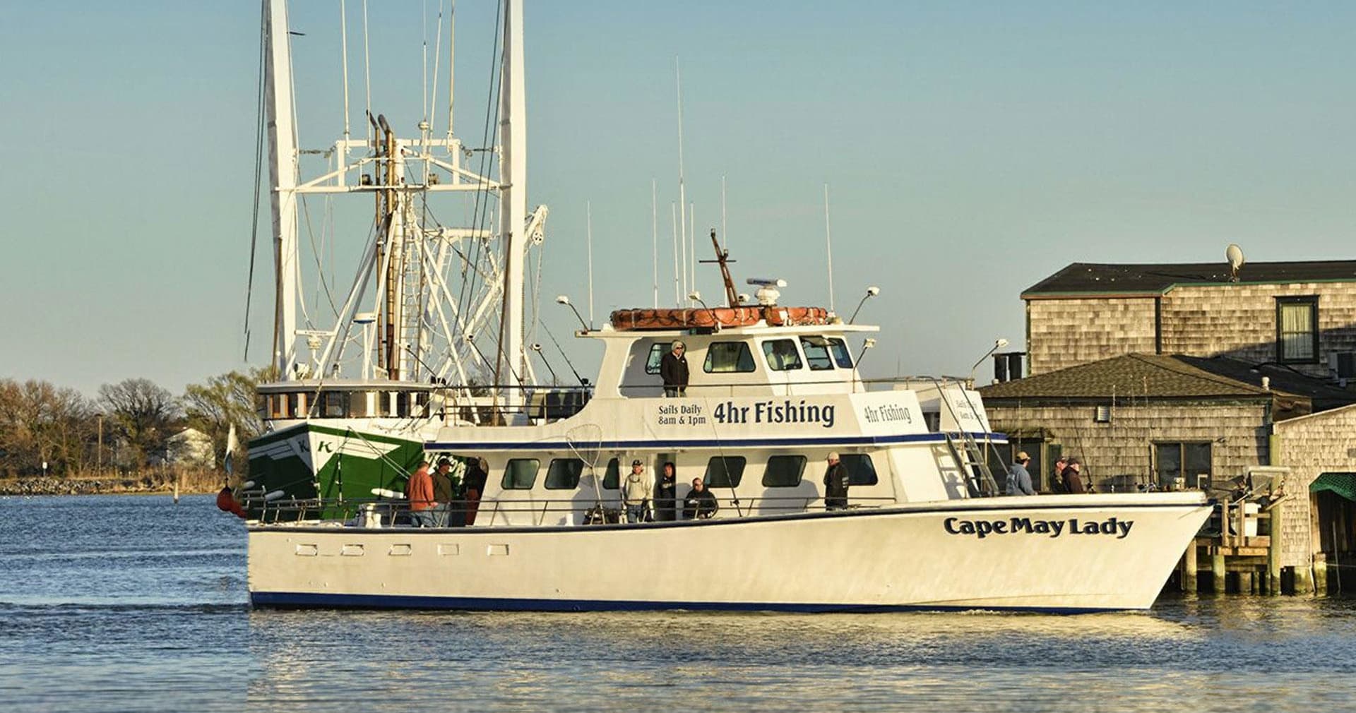 Fishing charter boat cruising near Cape May with crew on deck