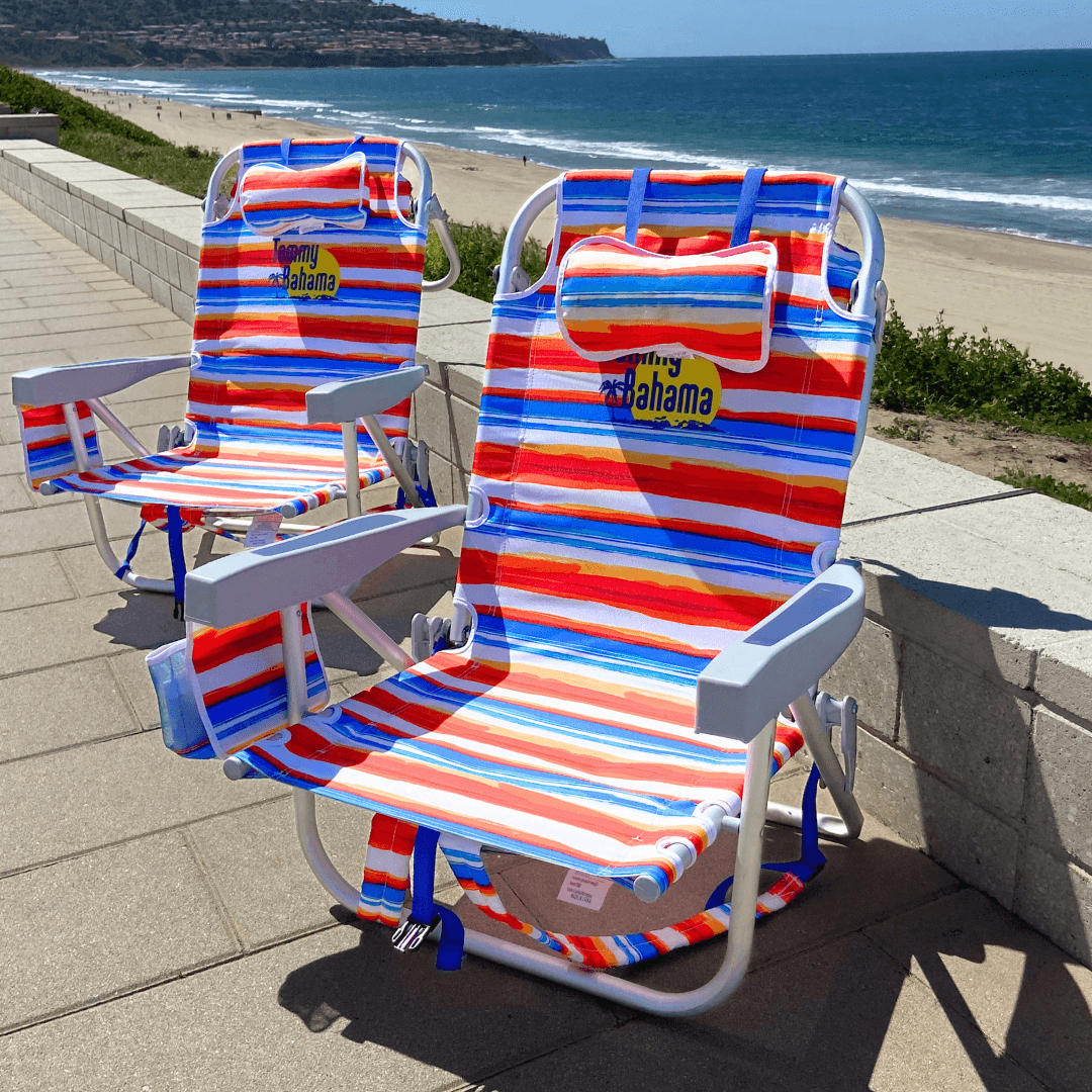 Pair of blue reclining beach chairs beside ocean waves