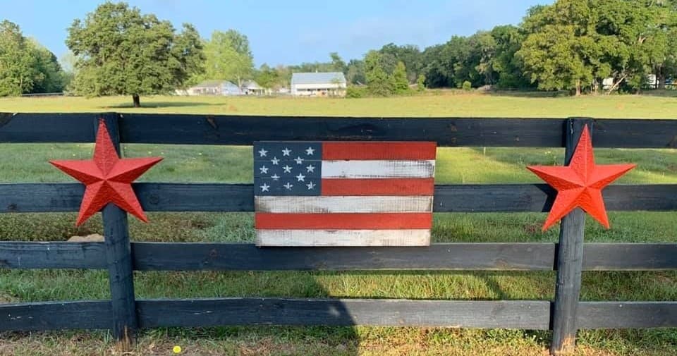 Decorative fence with American flag and red stars in farm field