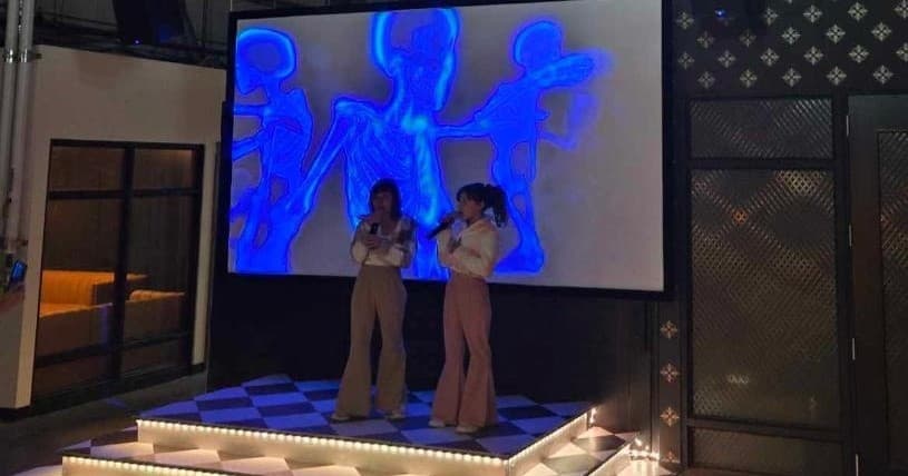 Stage performance at karaoke venue with dancers and large screen