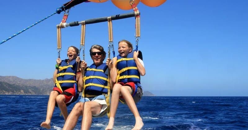 Three people parasailing over Annapolis bay with blue ocean