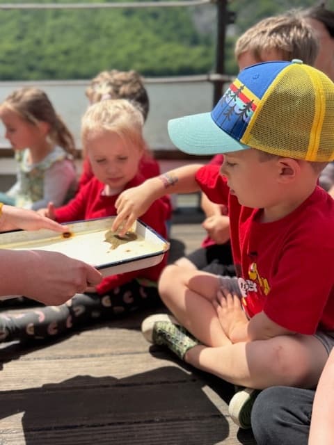 Children exploring marine life on dock during hands-on outdoor education