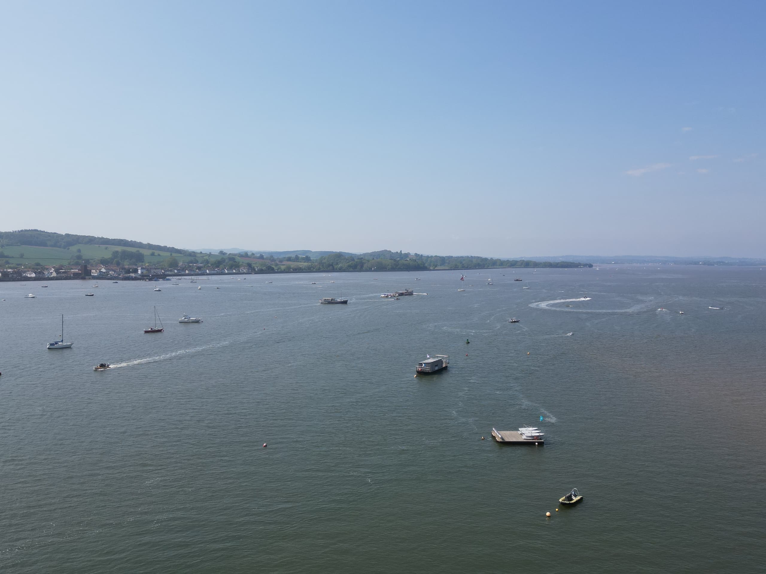 Wide harbor view with scattered leisure boats and distant coastline