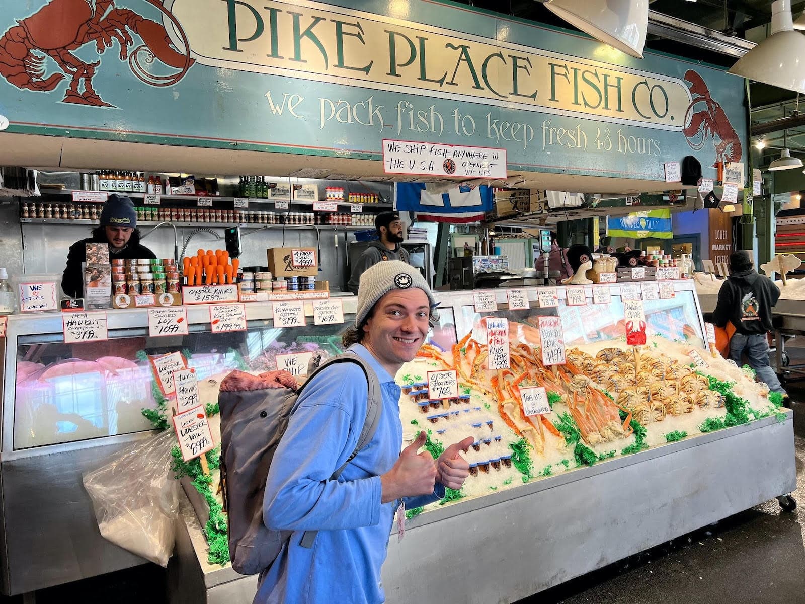 Visitor smiling by Pike Place Fish Co. seafood display