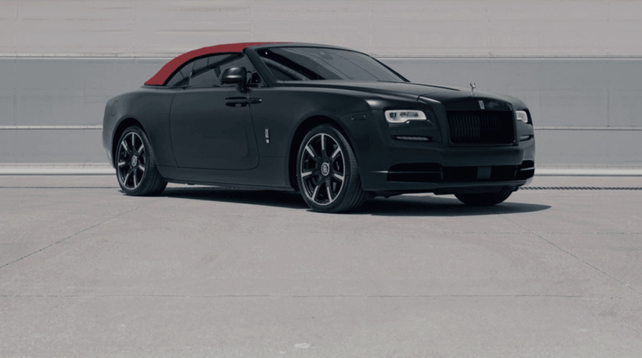 Black luxury sedan parked on urban overlook with skyline view