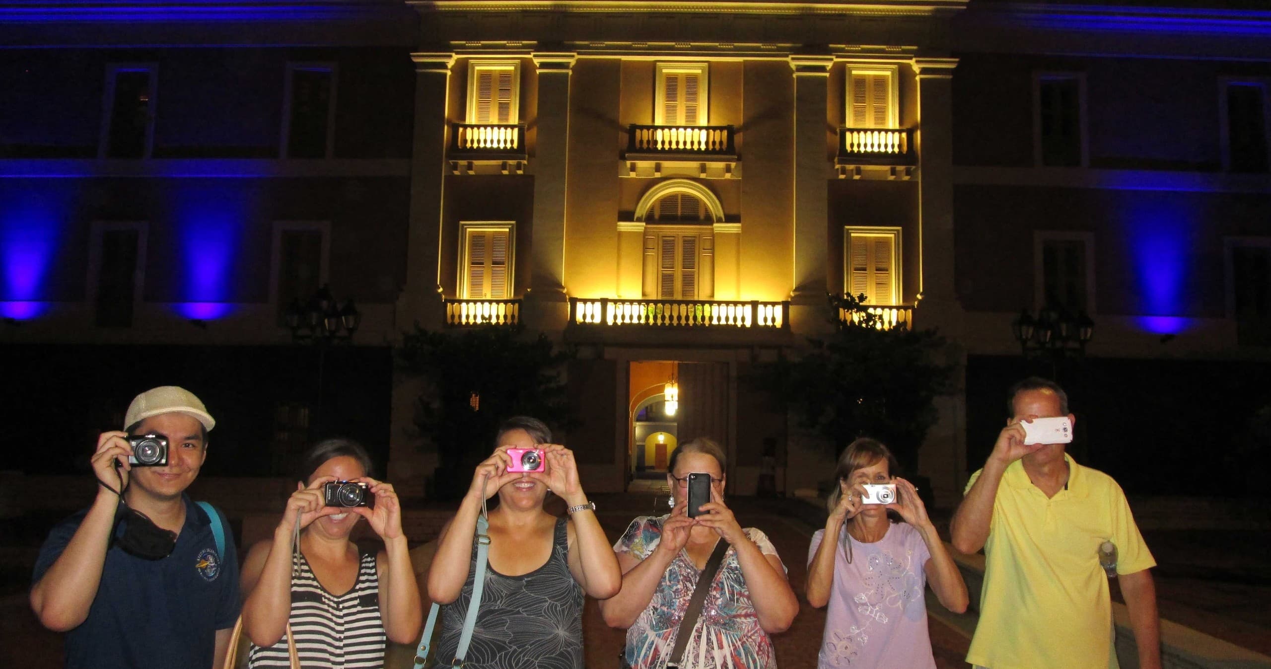 Nighttime walking tour group photographing illuminated square