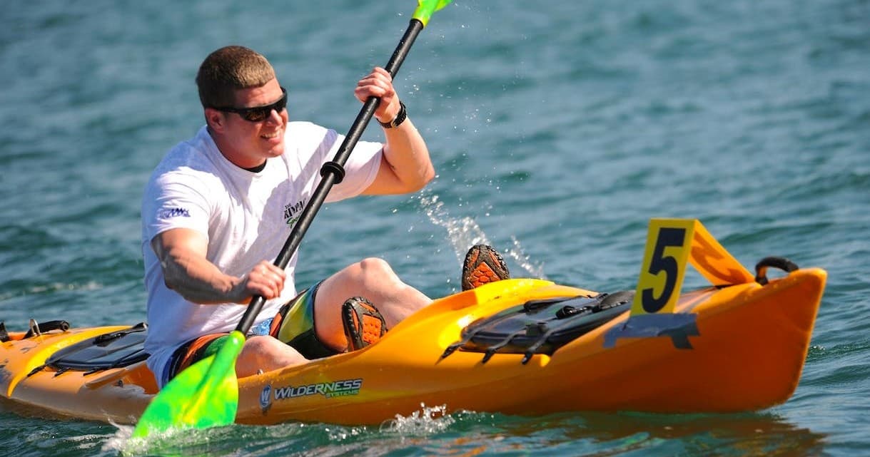 Competitive kayaker sprinting in open water during race event