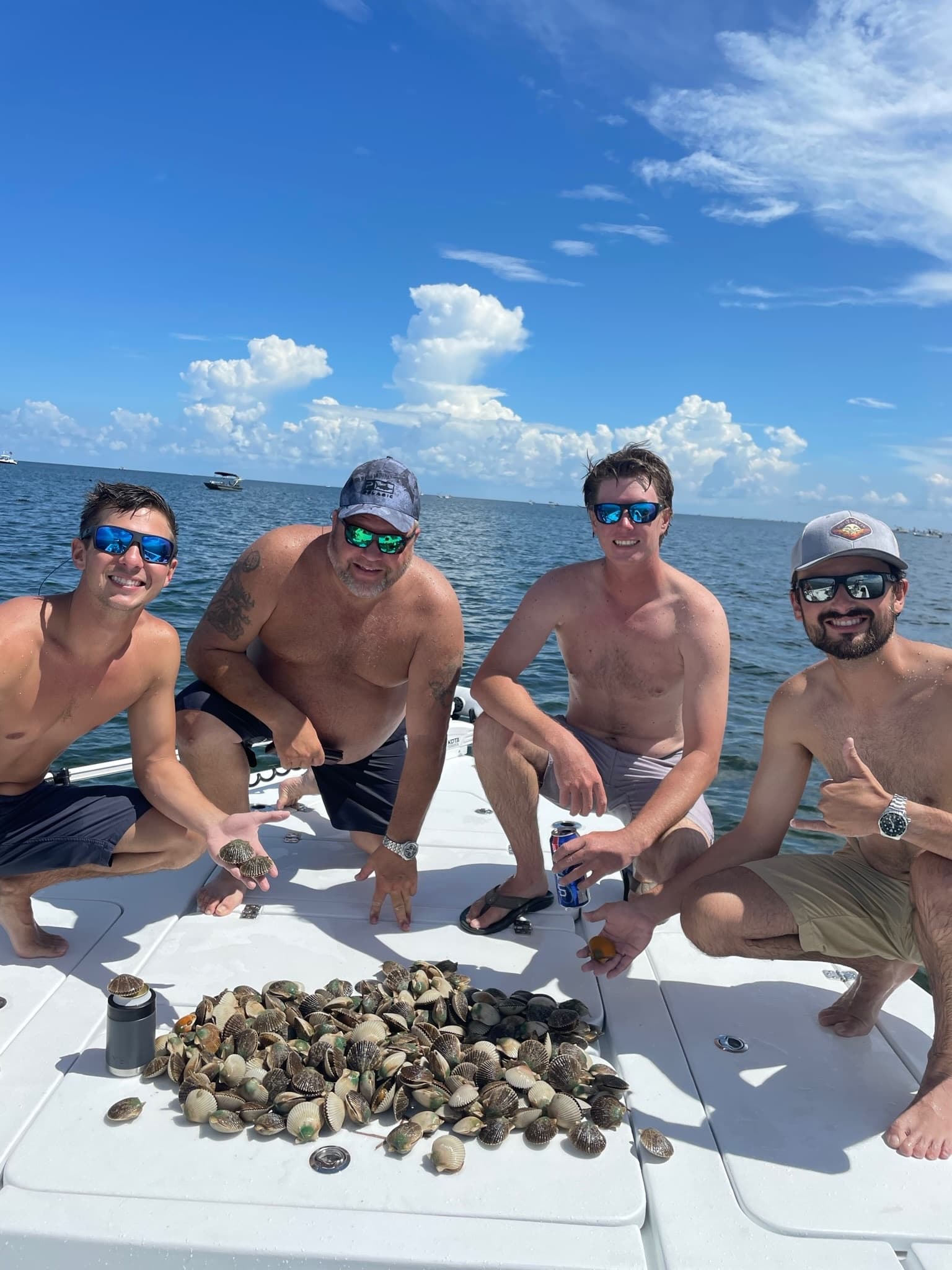 Group collecting clams on sunny Gulf of Mexico charter