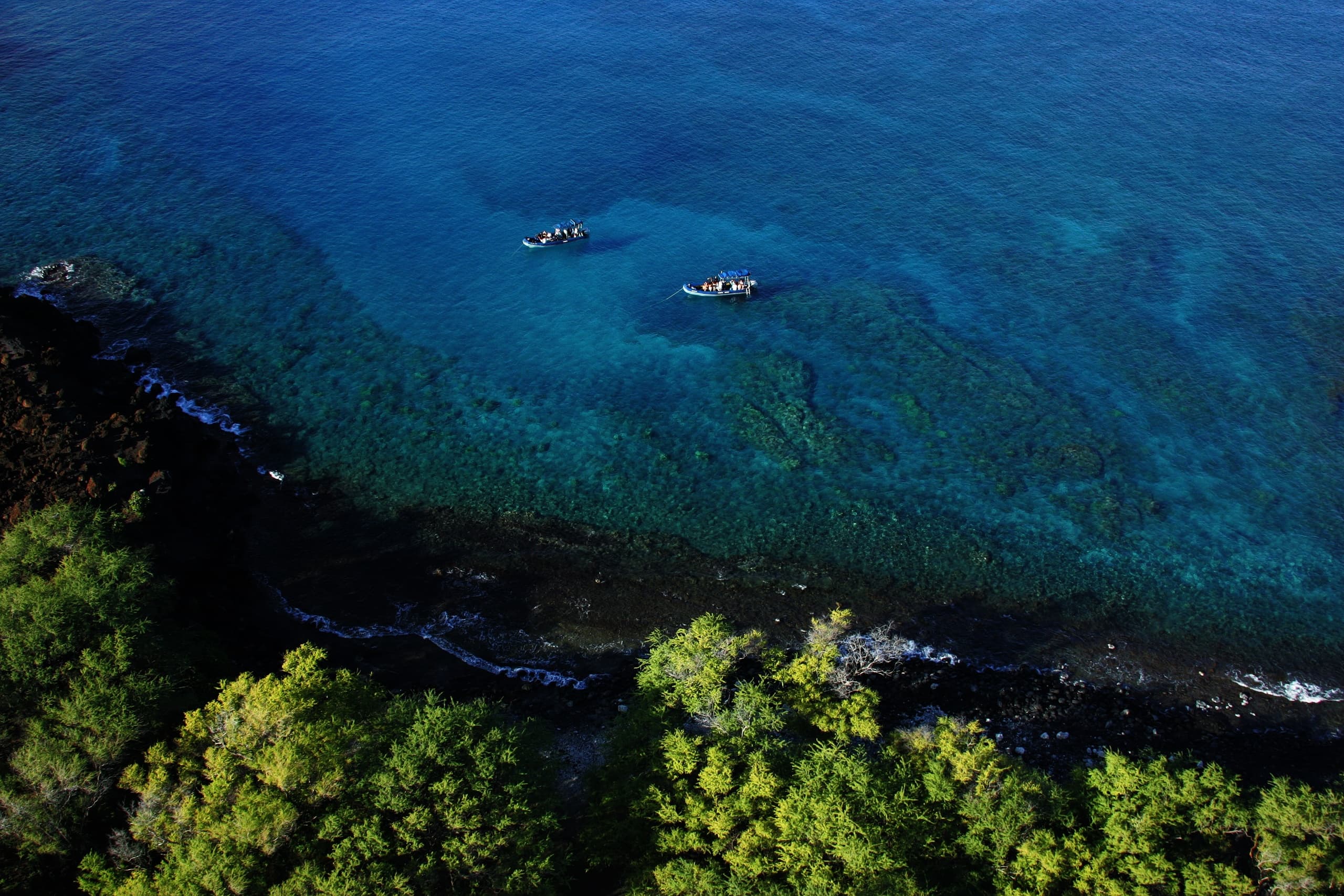 Aerial kayakers exploring clear tropical coastline waters