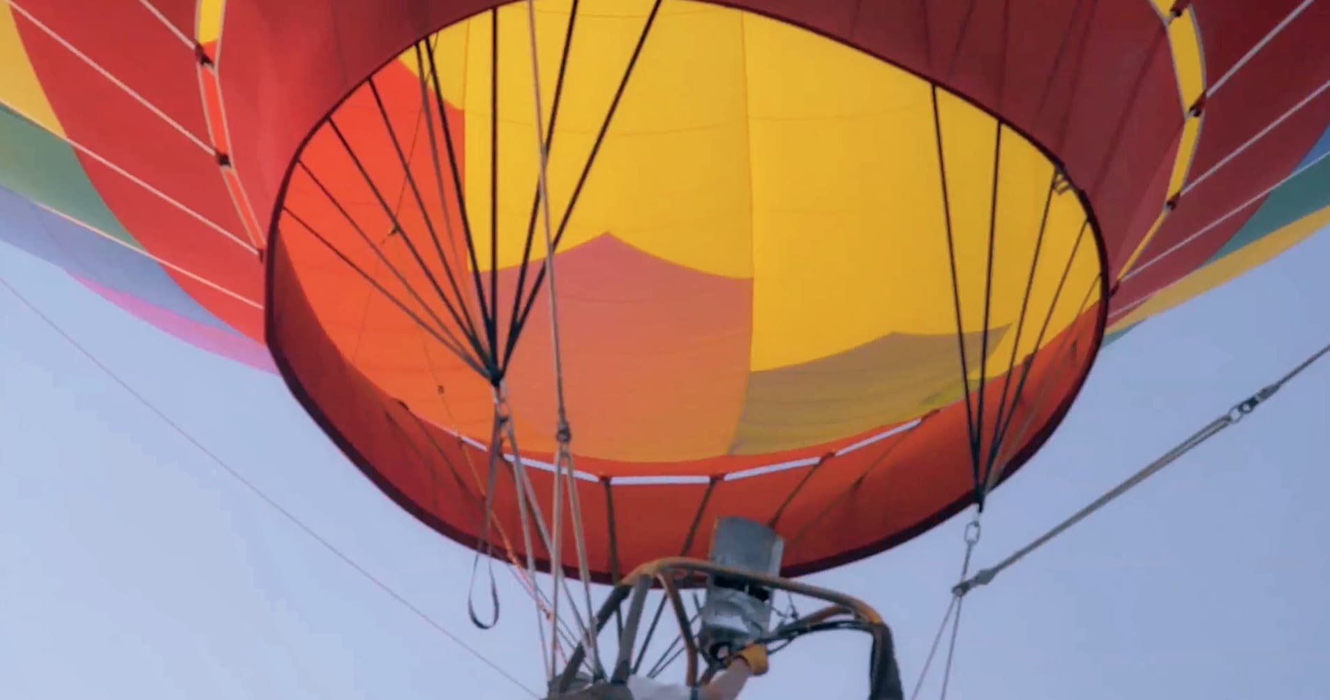 Close-up of colorful hot air balloon canopy and burner at launch
