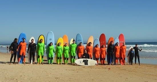 Group surf lesson with colorful boards lined up on beach
