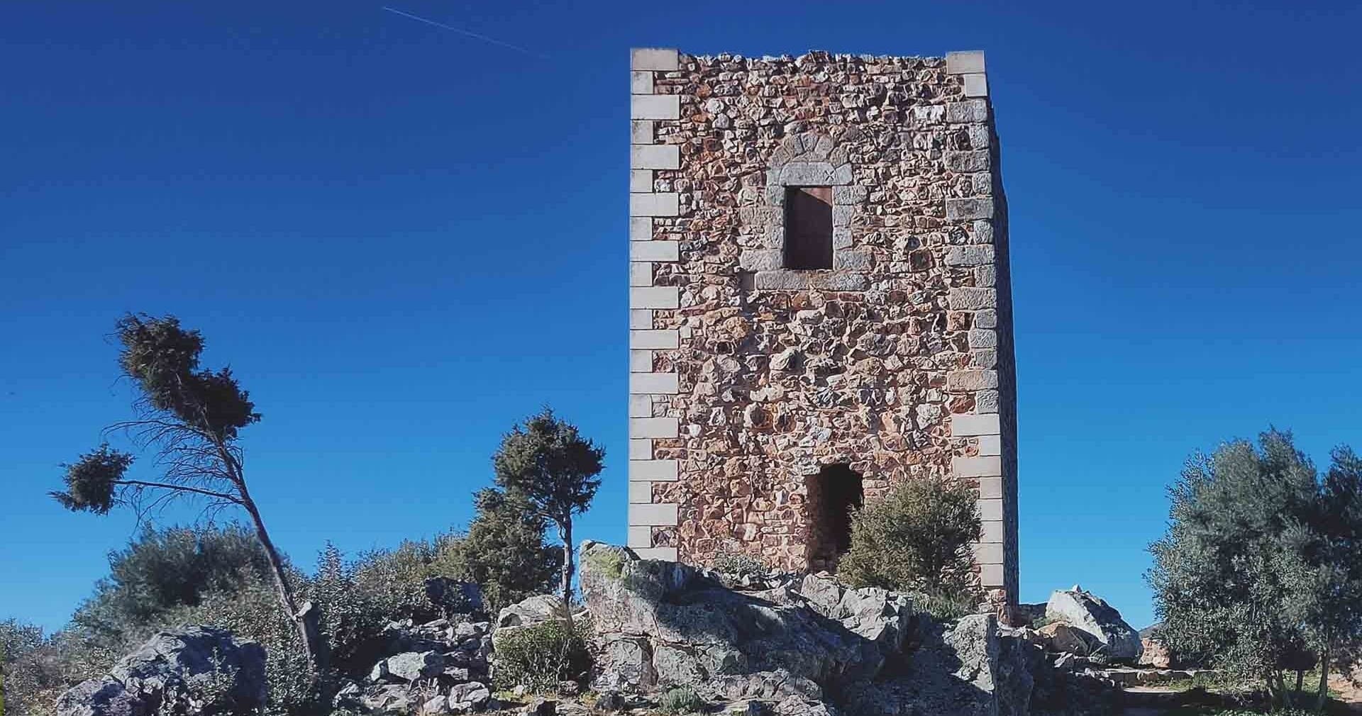 Ancient stone watchtower ruins on rocky hill with panoramic views