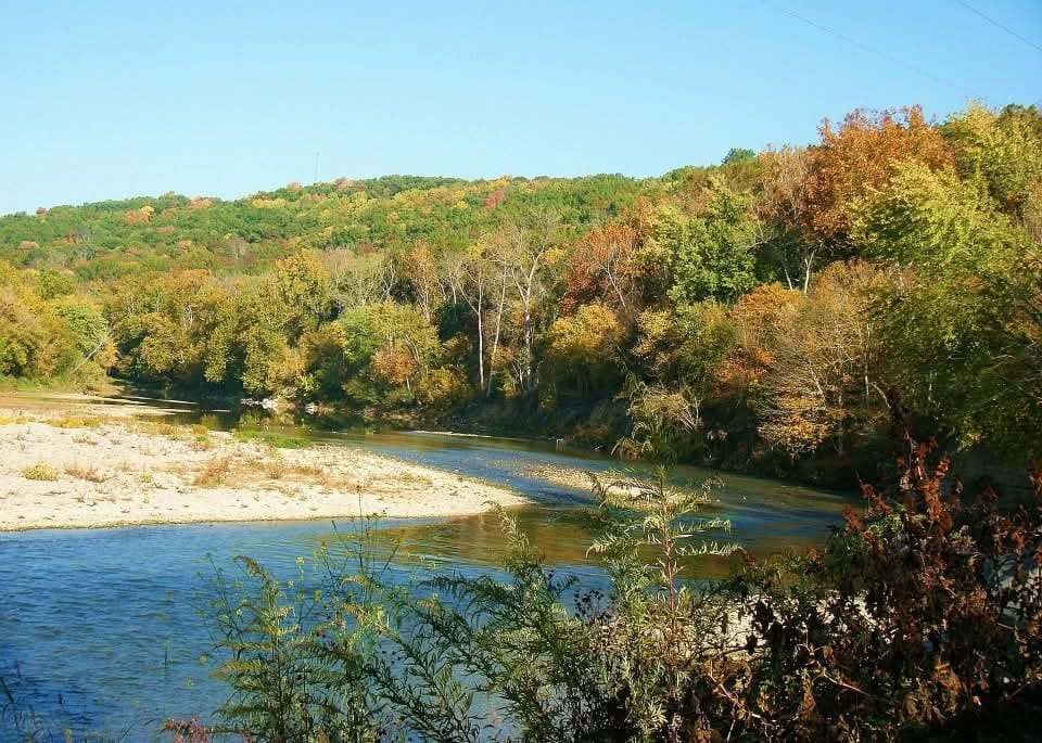 Scenic river bend with autumn trees along mild current