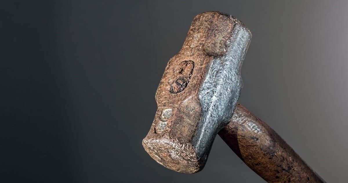 Close-up sledgehammer head on workshop surface indoor tool