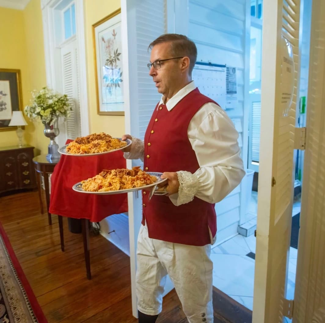 Server carrying platters in a historic dining room supper