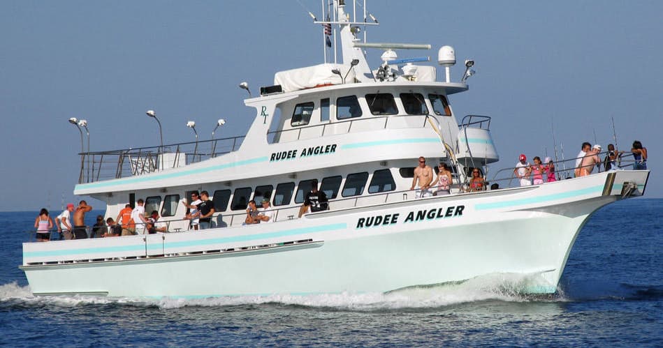 Charter fishing boat cruising offshore with anglers on deck