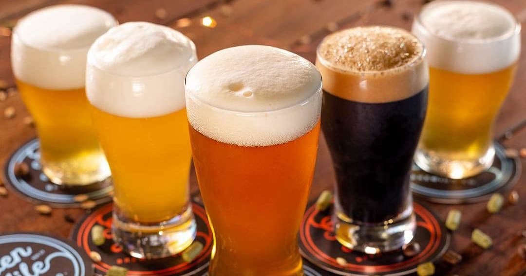 Flight of craft beers on wooden bar during brewery tasting