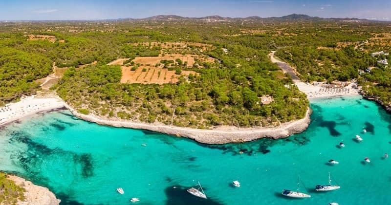 Aerial cove with turquoise water and anchored boats, Mallorca