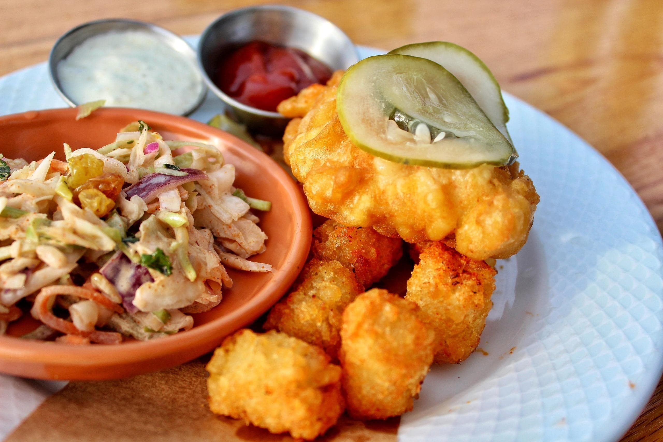 Crispy fried bites with slaw on plate at casual eatery