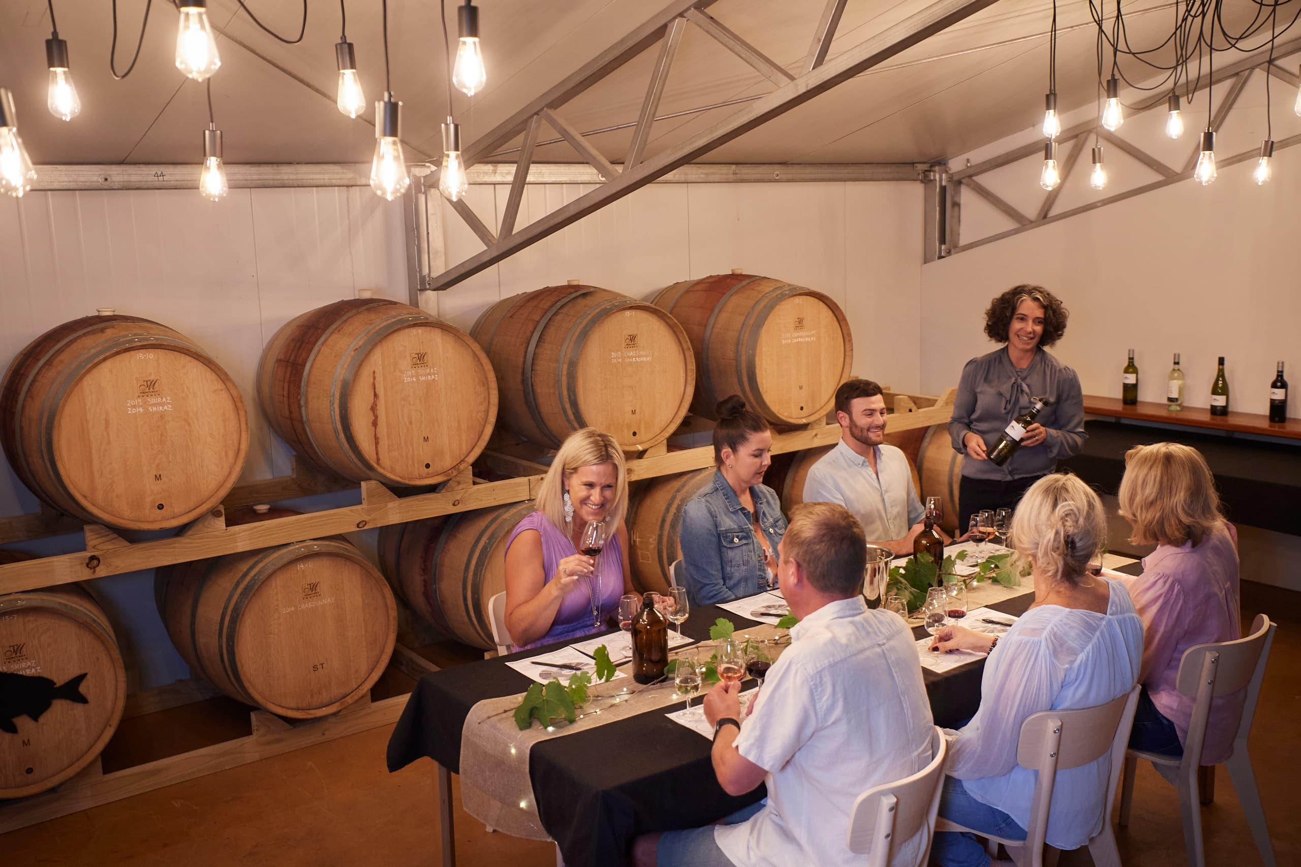 Group dining and wine tasting inside rustic barrel cellar