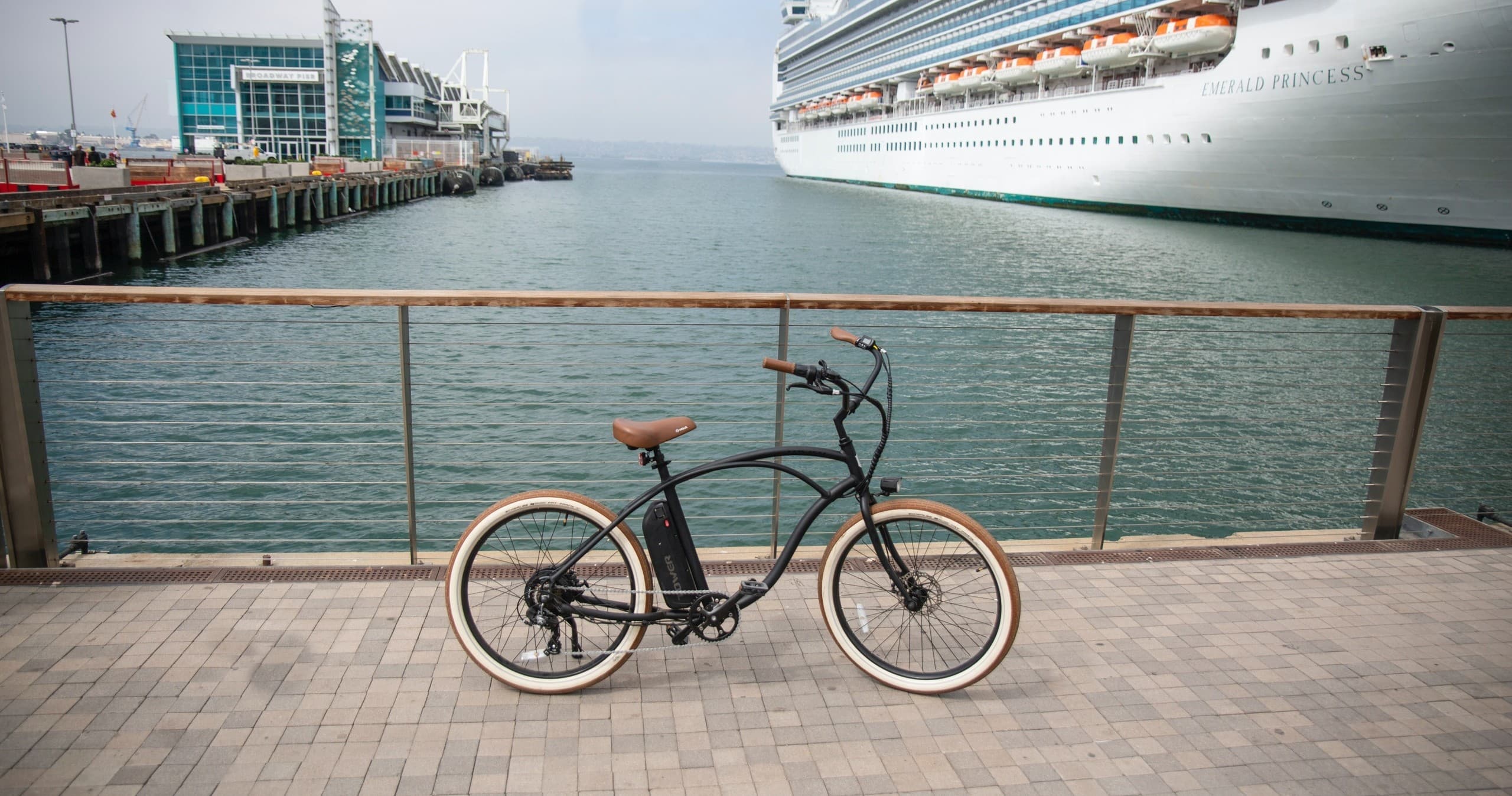 Electric cruiser bike parked on waterfront pier by cruise ship