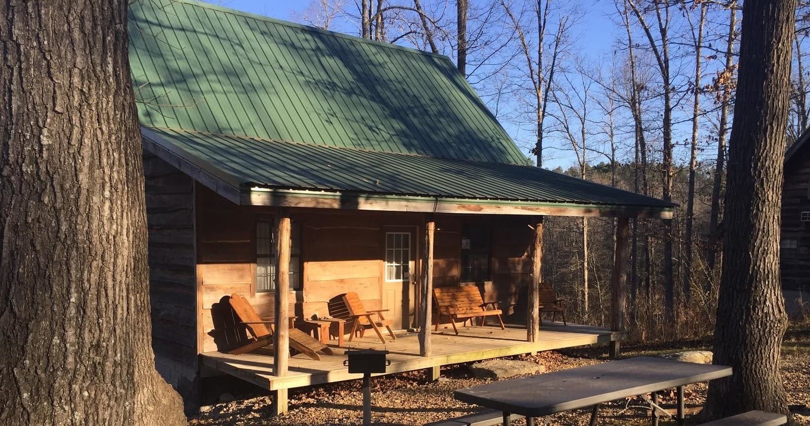 Cabin porch with green metal roof and rocking chairs outdoors