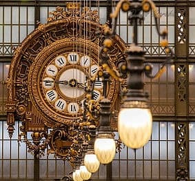 Ornate clock and lamps inside Musée d'Orsay interior, museum visit