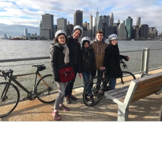 Women on rental bikes with Manhattan skyline across East River