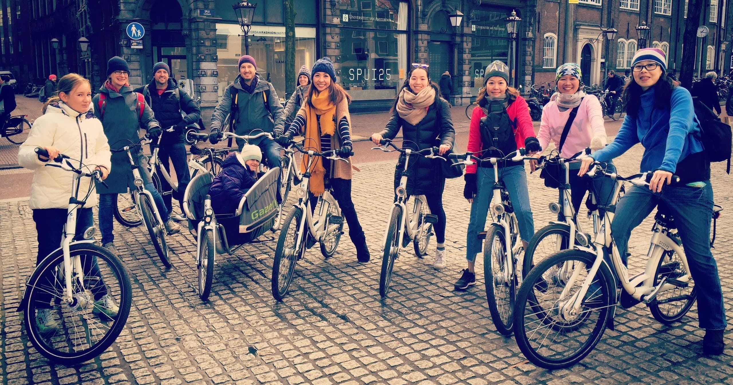 Amsterdam city bicycle tour group assembled in cobbled square