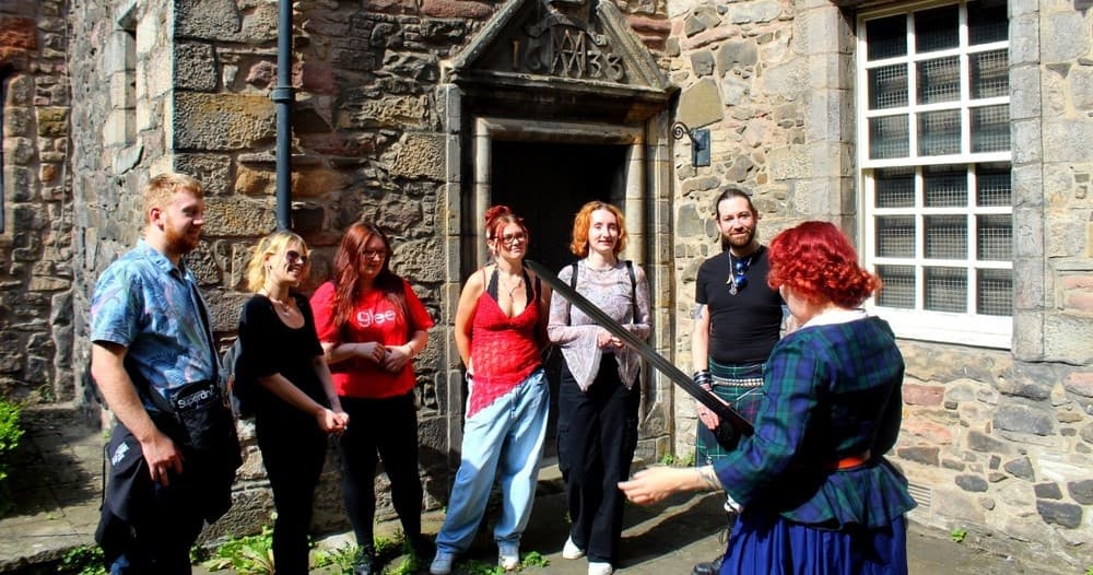 Guided pub crawl group outside historic stone building in Edinburgh