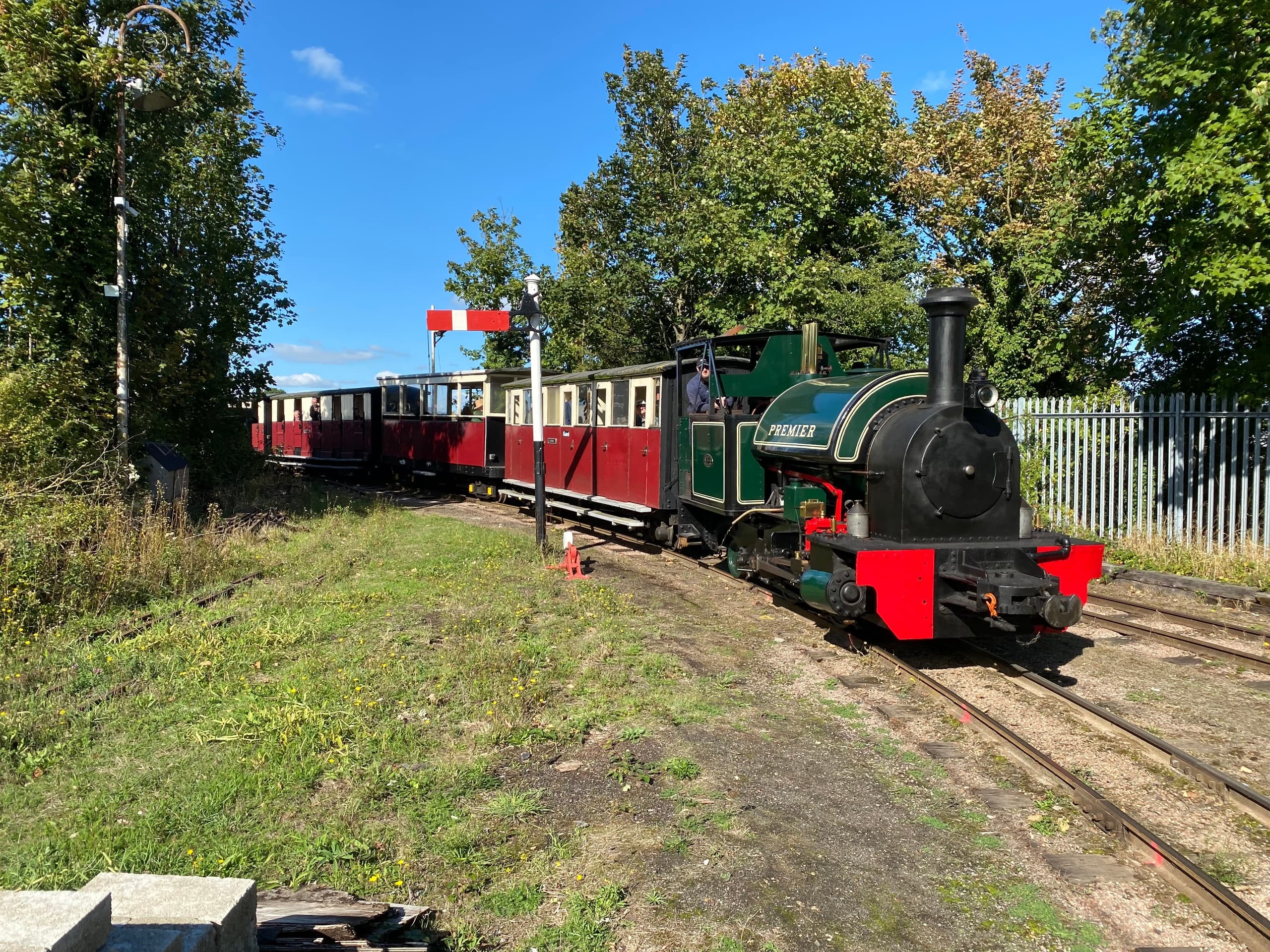 Heritage steam train traveling on countryside tracks under trees