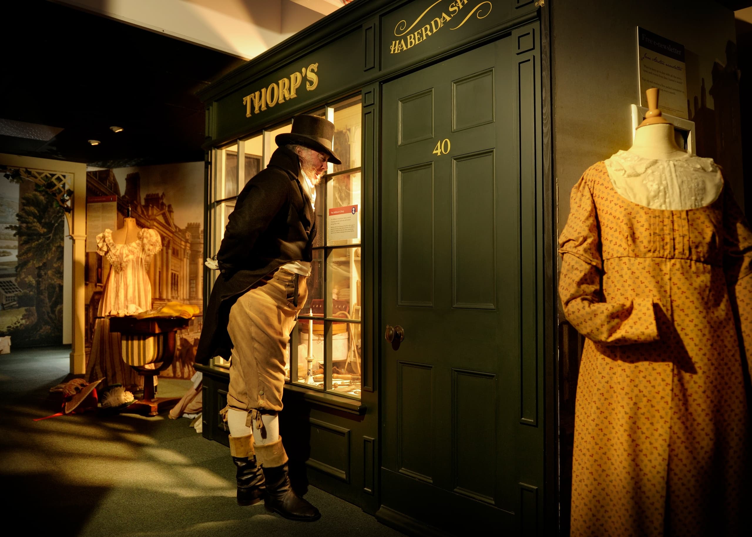 Visitor peering into historic costume shop exhibit in museum