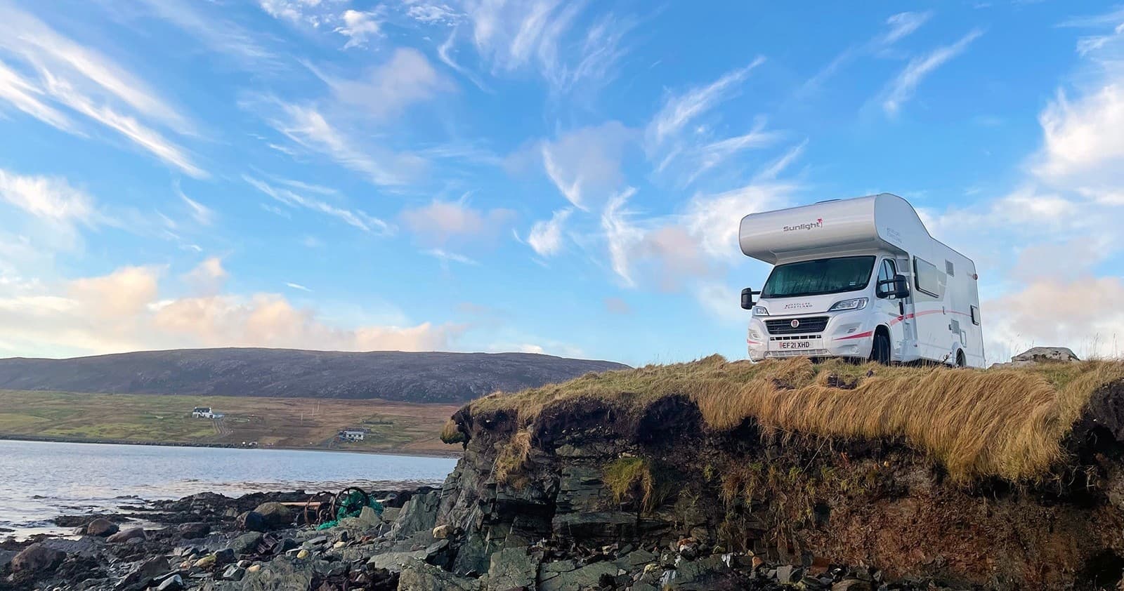 Campervan parked on coastal cliff overlooking Shetland seascape