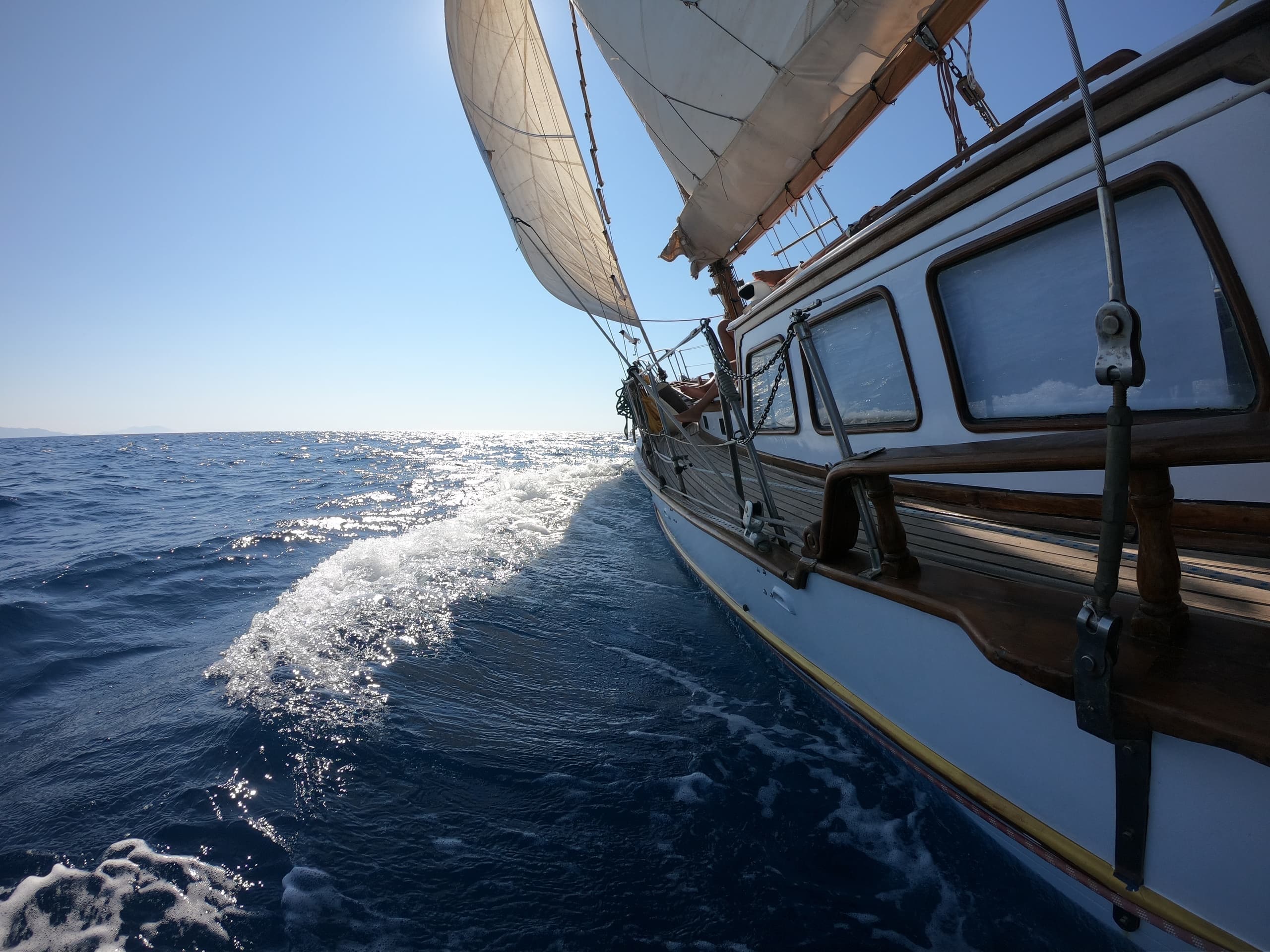 Close-up sailboat bow cutting through ocean waves, motion shot