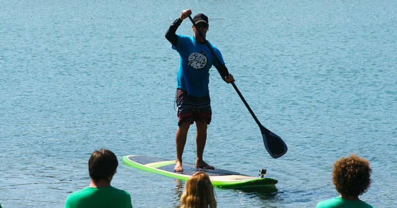 Stand-up paddleboard instructor on calm Byron Bay waters