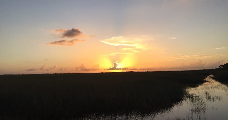 Sunset over Everglades marshland with reflective water channel