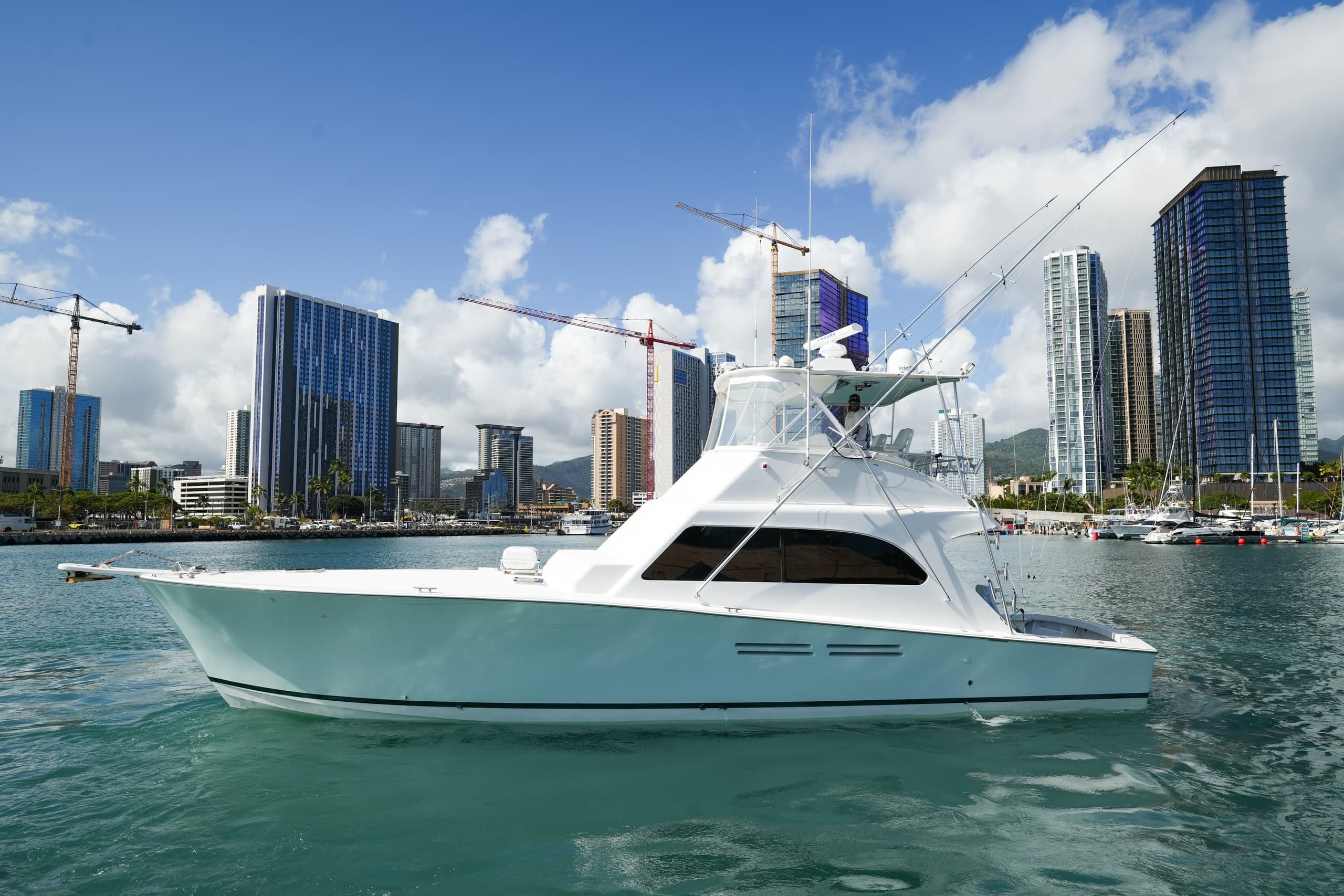 Luxury charter boat cruising near urban skyline marina harbor