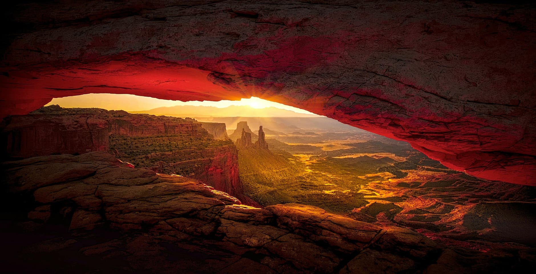 Sunrise framed through Mesa Arch overlooking canyon vistas