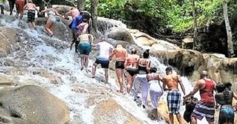 Group hiking up cascading waterfall rocks, guided jungle climb