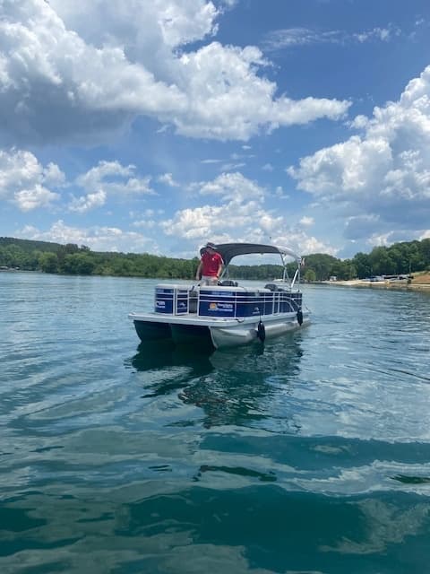 Pontoon approaching on Lake Keowee with cloudy sky backdrop
