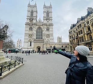 Tourist pointing toward Westminster Abbey facade on city walk