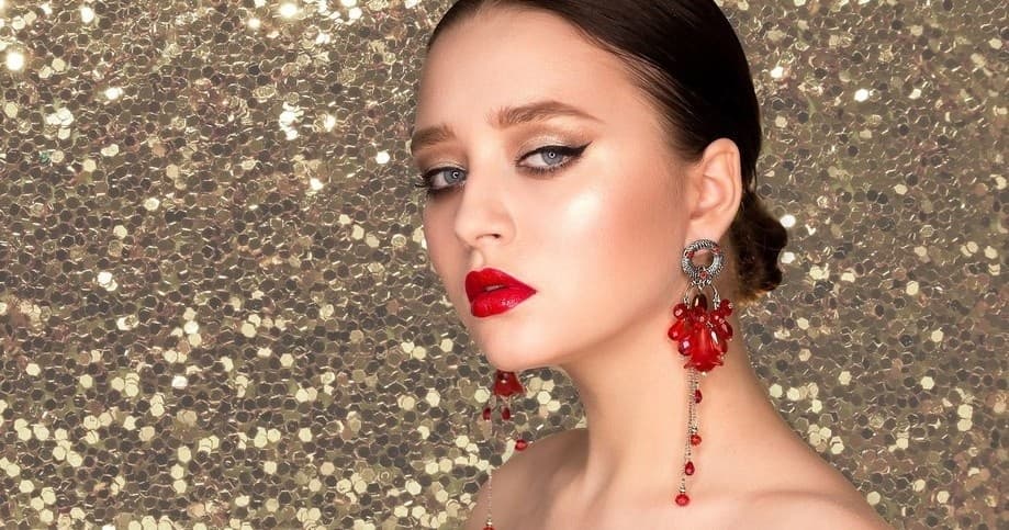Model wearing red lipstick in glitter studio makeup shoot