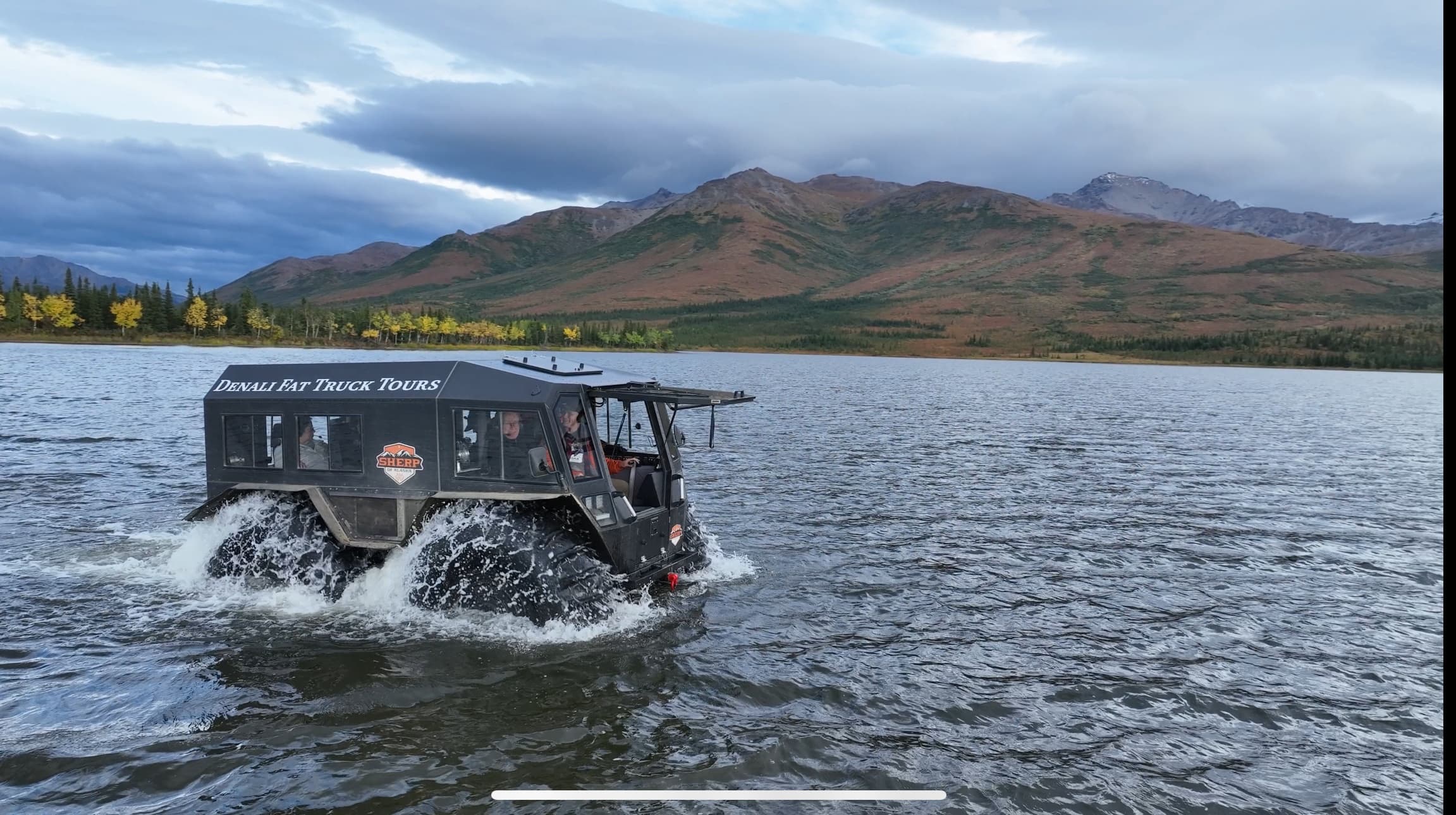 Amphibious tour vehicle cruising on Denali lake shoreline