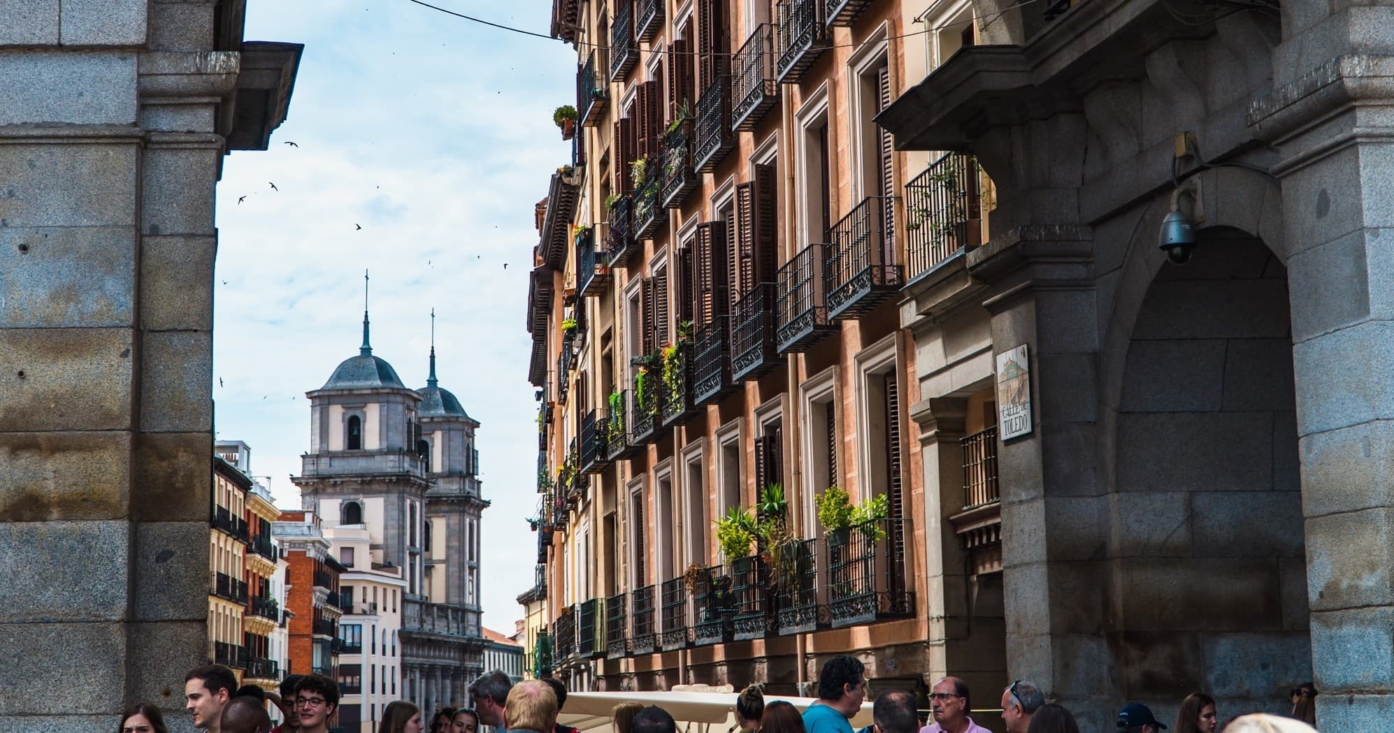 Narrow historic Madrid street with archway and balcony-lined facades