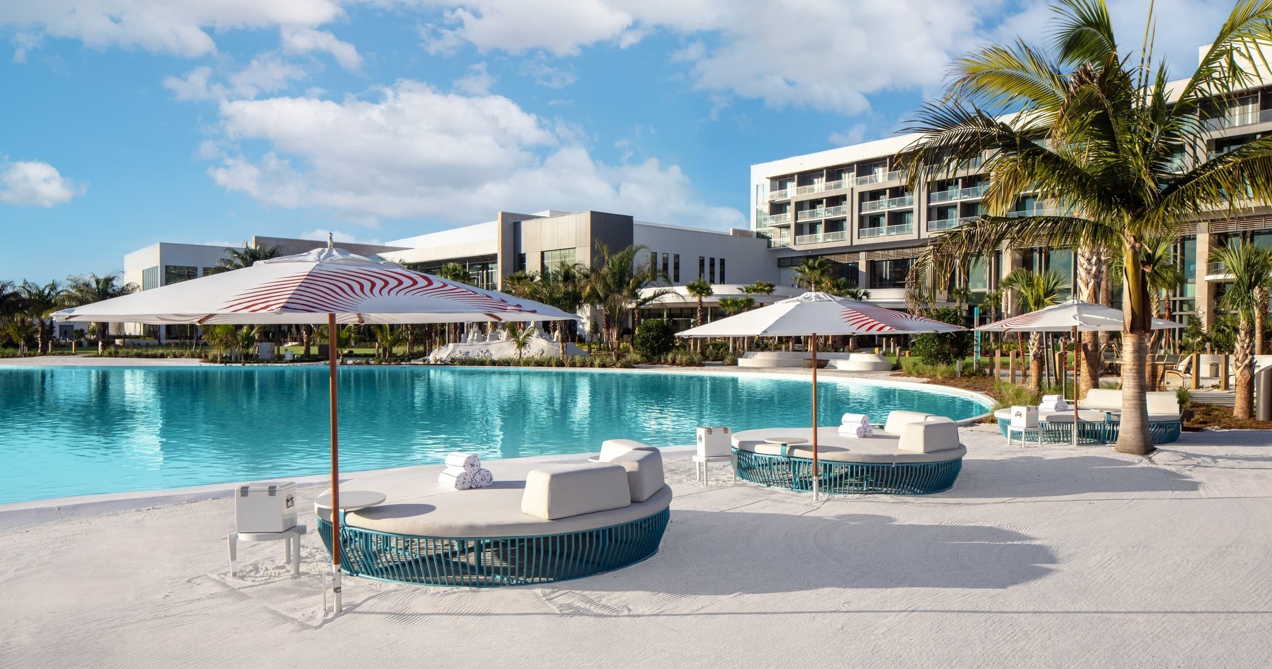 Luxury resort pool with round daybeds and tropical palm views